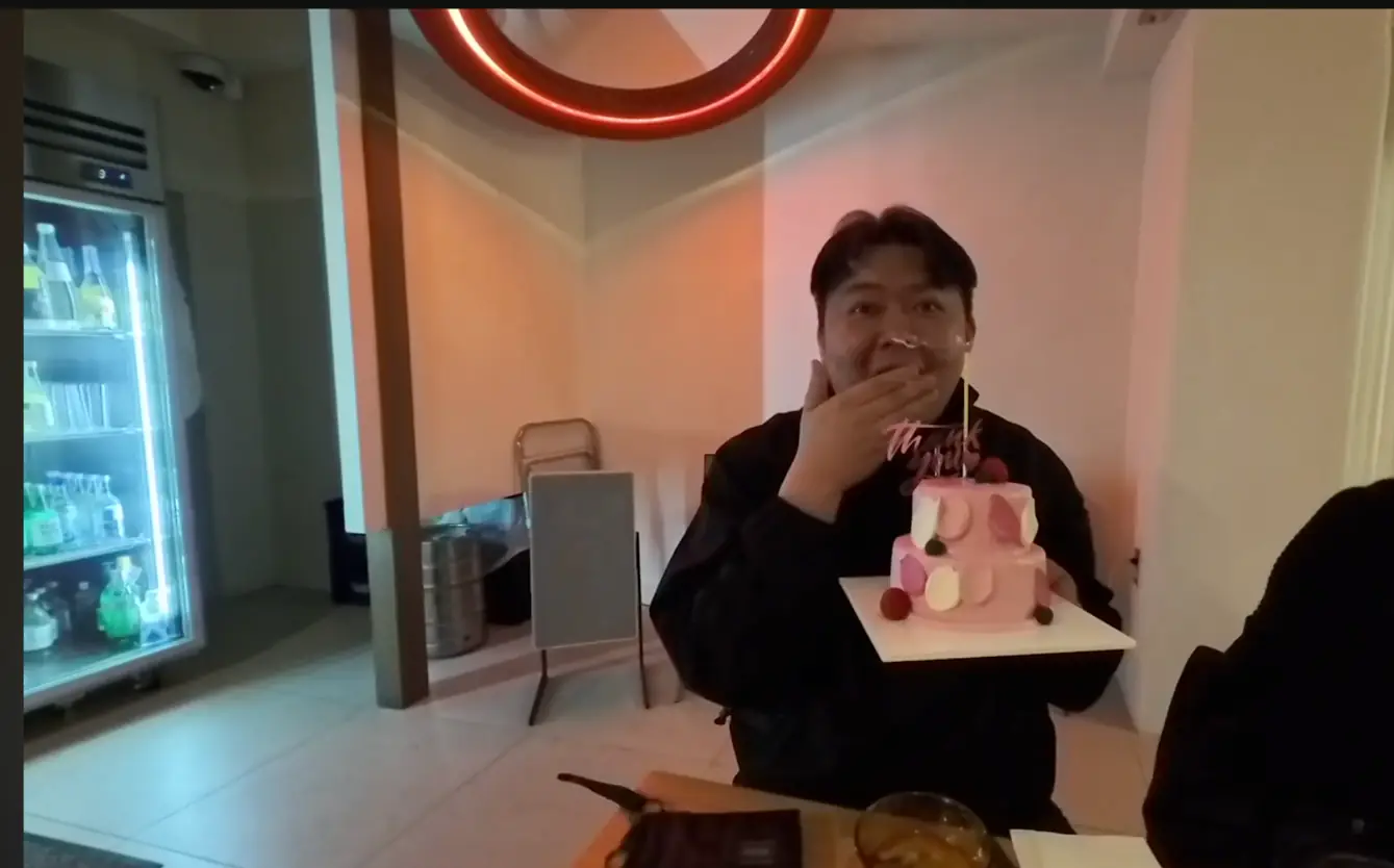 케이크를 받고 입을 가리며 웃는 모습