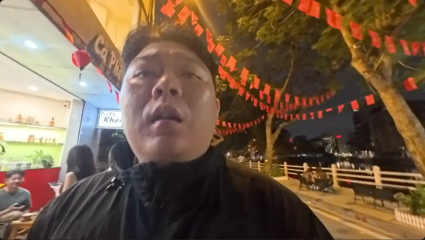 붉은 깃발이 걸린 밤 호숫가 길에 선 모습