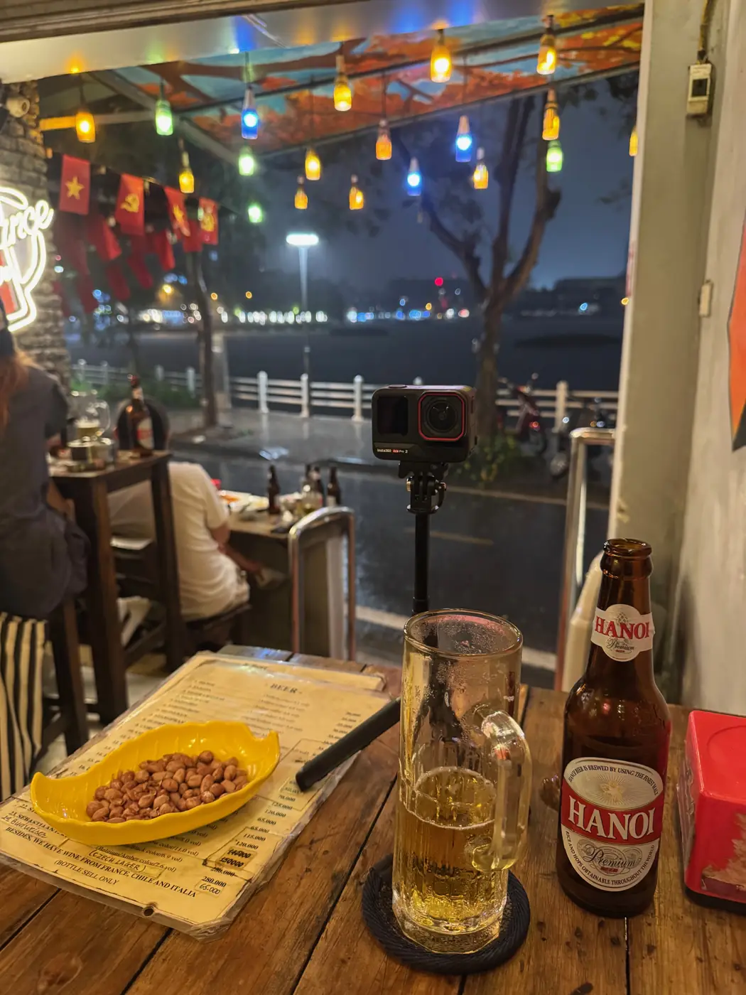 하노이 맥주병과 땅콩 접시, 창밖으로 보이는 밤 호수