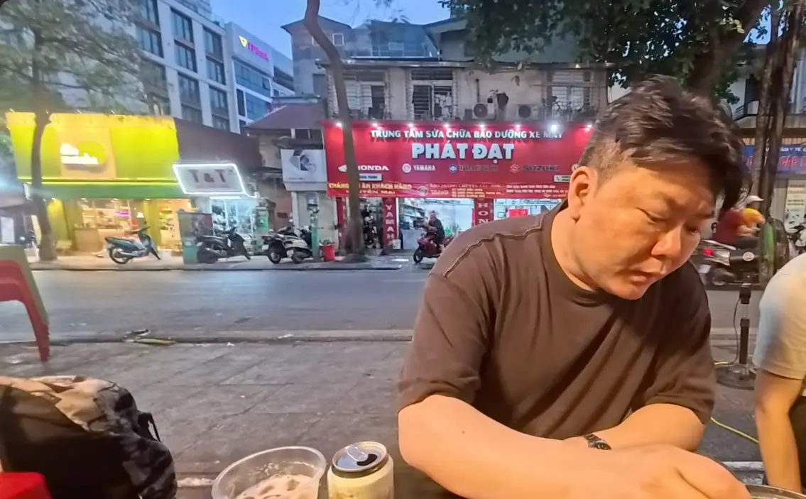 길가 해산물 식당에서 조개 국물을 떠먹는 모습
