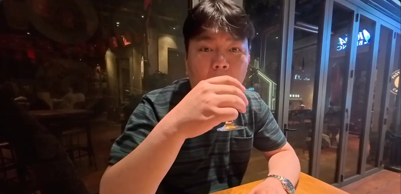 밤 맥줏집 창가에서 맥주잔을 든 모습