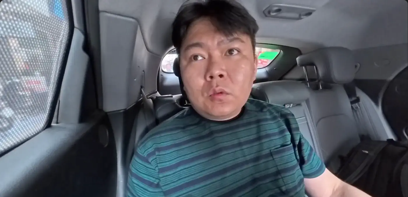 그랩 차 뒷자리에 앉아 걱정스러운 얼굴