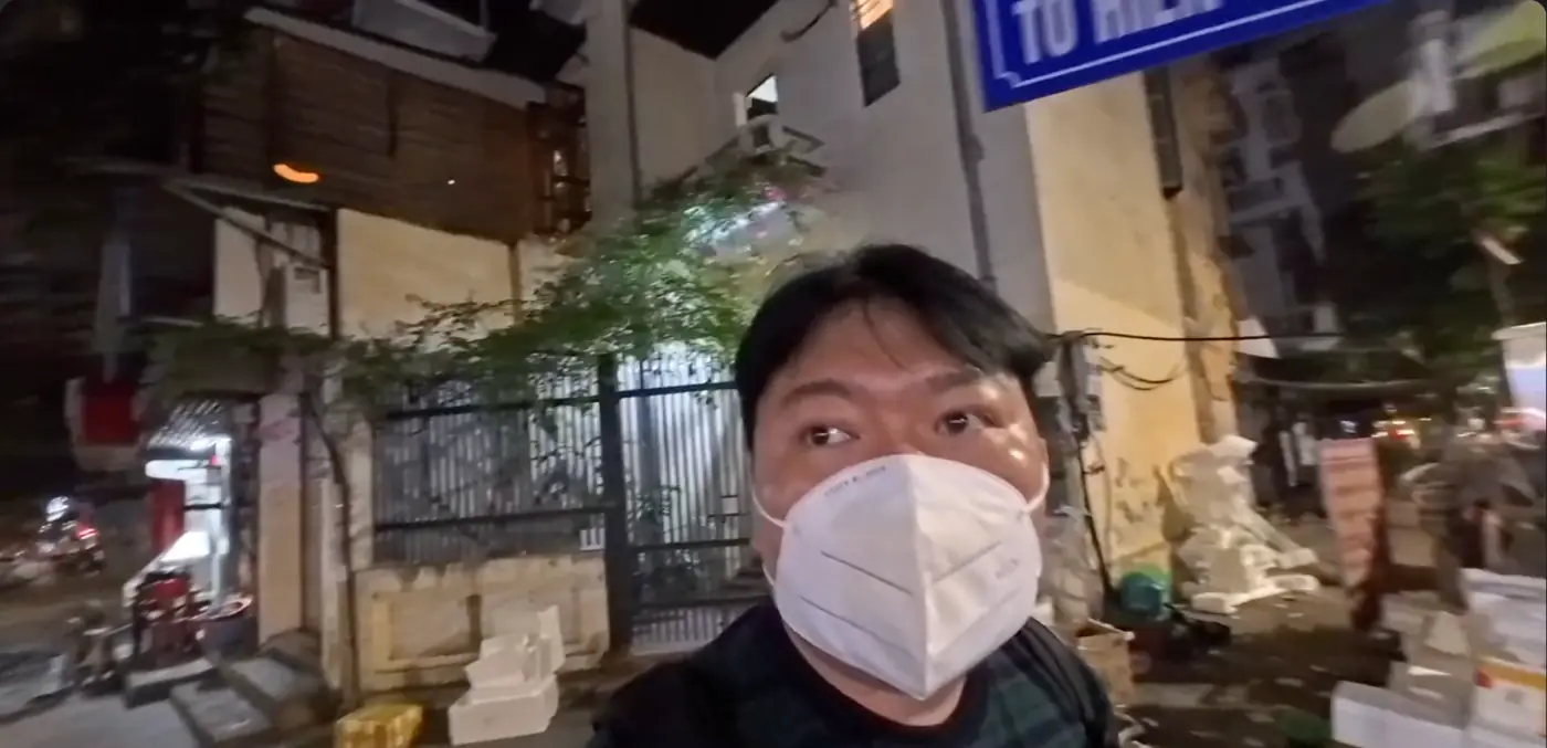 밤 골목에서 마스크를 쓴 모습과 파란 거리 표지판