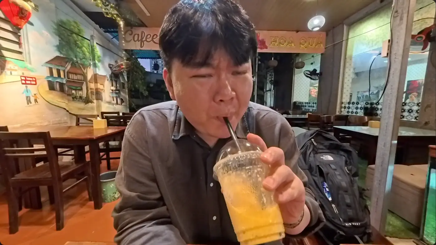 다 녹은 망고 음료를 빨대로 마시는 모습