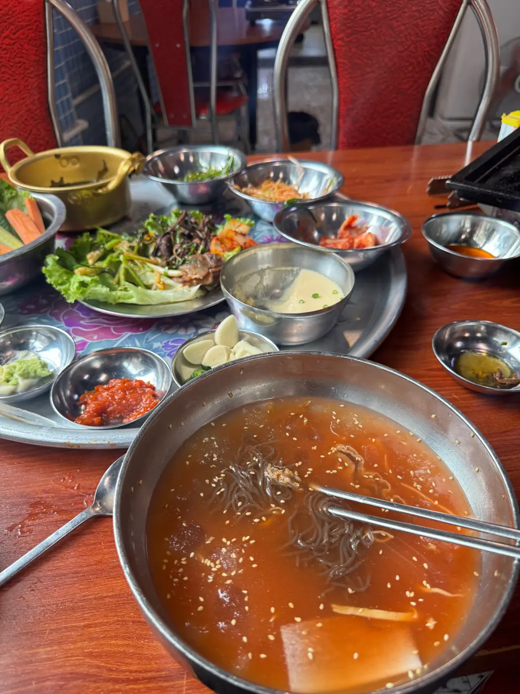 양은 그릇에 담긴 냉면과 반찬 쟁반